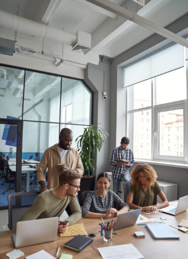 successful-team-coworking-space-vertical-shot-multiracial-coworkers-communicating-sharing (1)